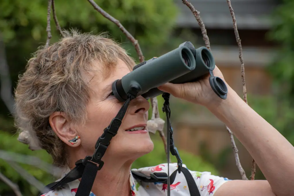 A person uses binoculars to observe the vibrant life around Lake Conroe, embracing the adventurous side of non-water activities.