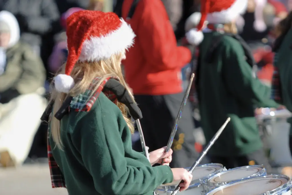 Drummers in green coats and Santa hats bring festive cheer to the holiday parade by Lake Conroe.
