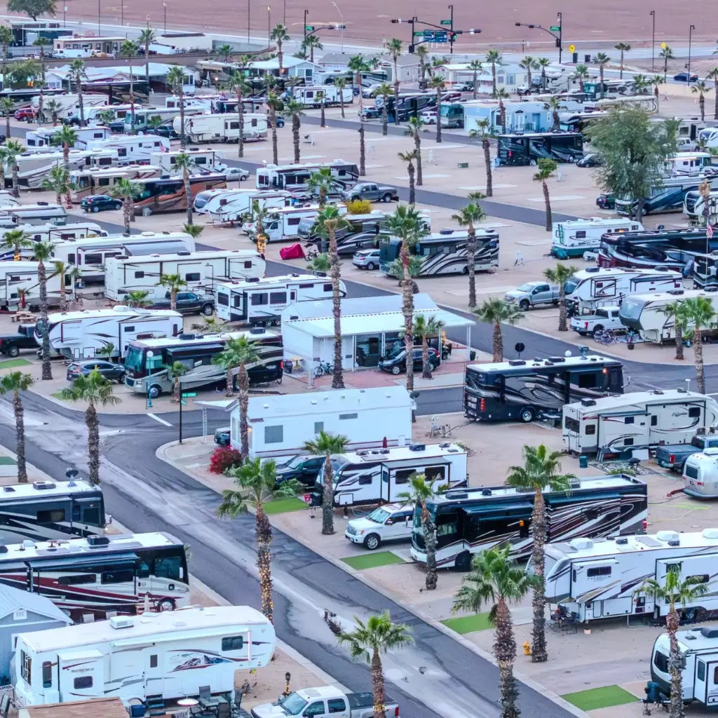 Early booking offers benefits for Arizona winter visitors, including prime spots among the palm trees and numerous recreational vehicles visible from an aerial view of the expansive RV park.