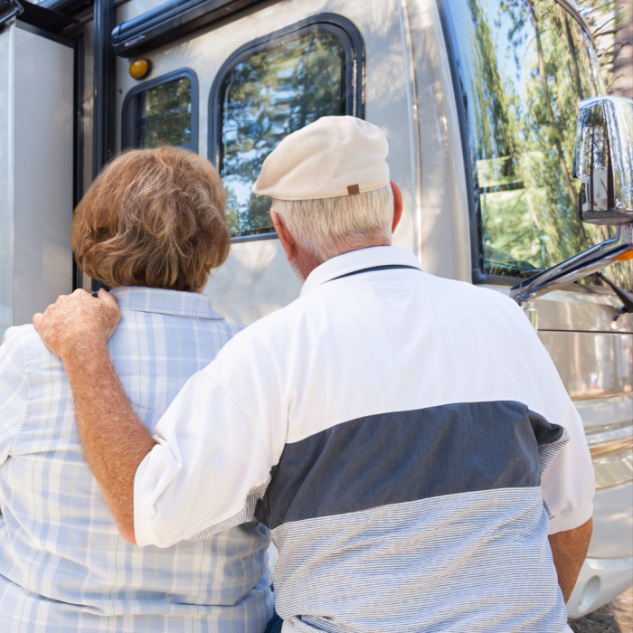 An older couple stands closely, arms wrapped around each other, as they admire their secure RV site.