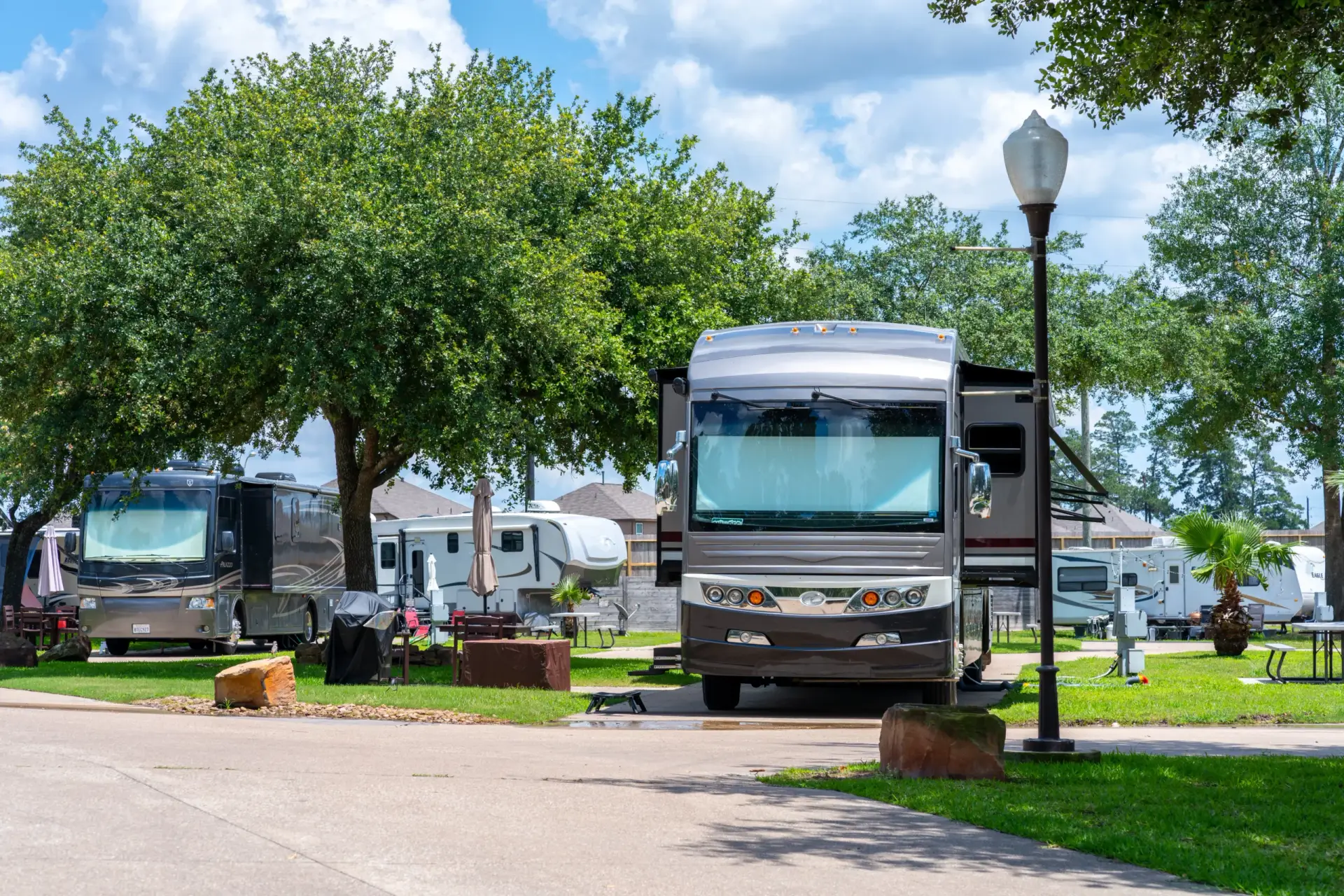 RVs parked under trees in a sunny RV park create the best stay experience, with street lamps casting a gentle glow under the clear sky.