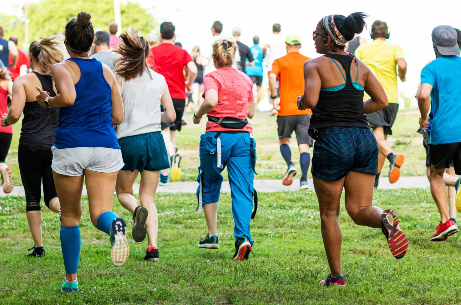 A group of people jogs along a grassy path in Austin, soaking up the vibrancy of November activities. They're decked out in colorful athletic clothing, capturing the spirit of Austin events in November with every step.